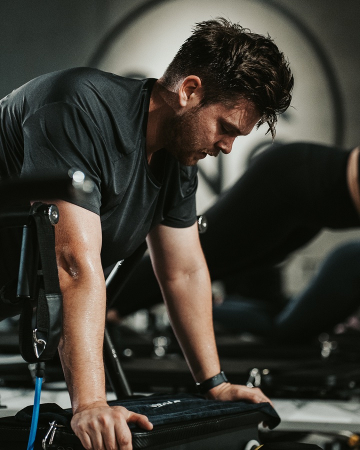 A man mid-session at STRONG Pilates